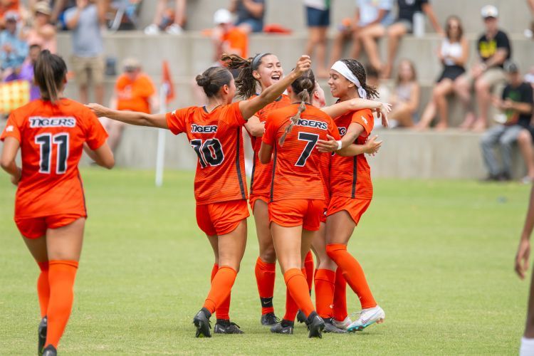 women's soccer players celebrate on the field
