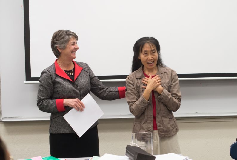 Provost Maria Pallavicini informing Professor Xiaojing Zhou that she had won the 2015 Distinguished Faculty Award.
