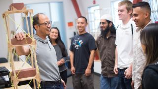 A professor talking with students in a lab.