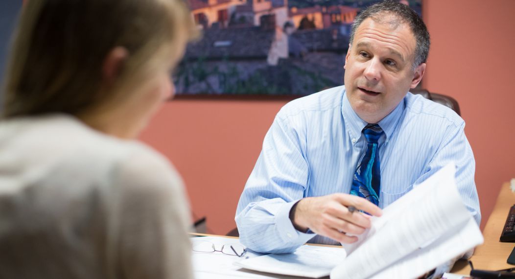 Bill Herrin talks with a student in an office setting